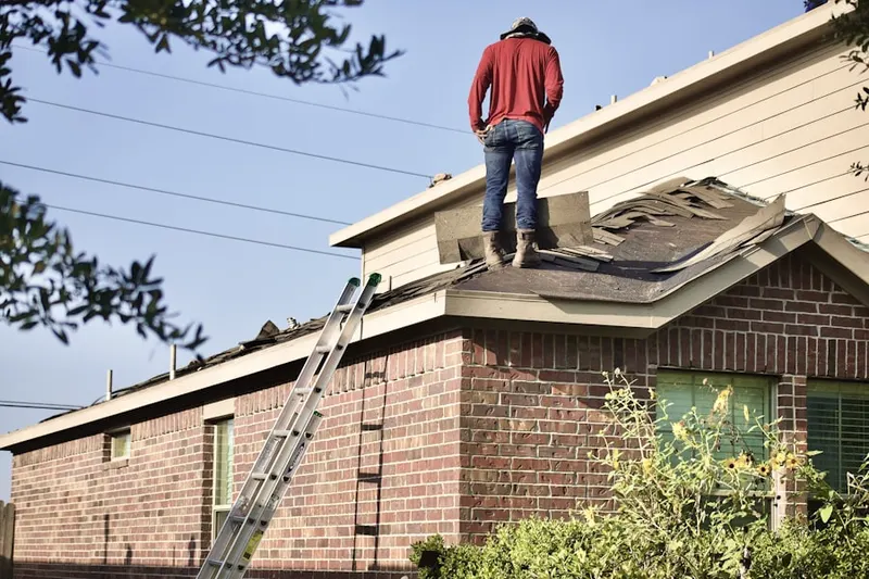 Professional roofer working on a residential roof in Wellston